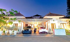 two cars parked in front of a house at Surfrider Yogyakarta in Yogyakarta