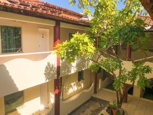 una casa con un árbol delante de ella en Porto Center Hotel, en Porto Seguro