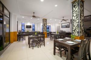 a dining room with tables and chairs in a restaurant at Viet Long Hoian Beach Hotel - STAY 24H in Hoi An