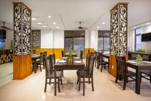 comedor con mesas y sillas de madera en Viet Long Hoian Beach Hotel - STAY 24H, en Hoi An