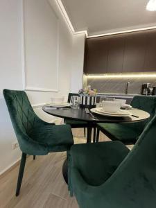a dining room with a table and green chairs at LUXURIOUS COMFORT IN CASCADAS in Sunny Beach
