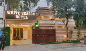 a man standing in front of a white season hotel at Hotel white season Gulberg in Lahore