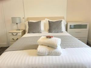 a bedroom with a white bed with towels on it at Robinhuts - 3 Bed Accommodation -Perfect for Contractors, Families & Students in Hull
