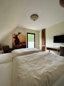 Schlafzimmer mit einem großen weißen Bett und einem Schreibtisch in der Unterkunft Jagdhaus Rech - Ahr in Rech