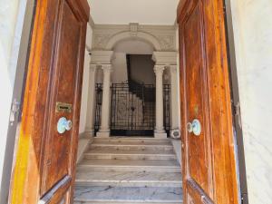 uma porta de madeira aberta com escadas num corredor em Allegra Viareggio Appartamento & Affittacamere Guest house em Viareggio