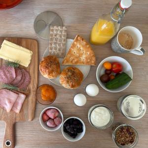a wooden table topped with different types of food at Havsbadens B&B in Ängelholm +10 photos
