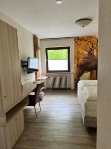ein Hotelzimmer mit einem Schreibtisch und einem Bett in der Unterkunft Jagdhaus Rech - Ahr in Rech