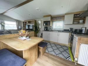 una cocina con mesa de madera y barra en Beautiful 6 Berth Caravan With Decking In Norfolk Ref 89001mv en Belton