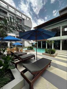 - une terrasse avec 2 tables de pique-nique et un parasol bleu dans l'établissement Benteh Aqua View, à Banjul