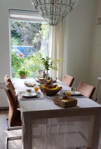 una mesa con comida delante de una ventana en Overbosch en Bilthoven