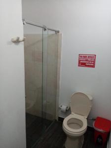 uma casa de banho com um WC e uma cabina de duche em vidro. em Hotel La Casona em Chinácota