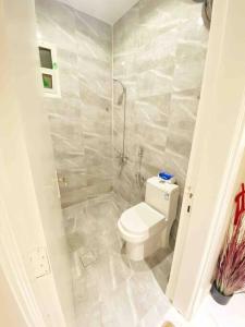 a white bathroom with a toilet and a shower at Smart Entry Apartment w Pvt Entrance 3B in Riyadh