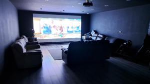 a living room with two couches and a projection screen at GF Studio, Secure parking, outside area, cinema(S) in Hurn