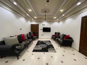 a living room with couches and a flat screen tv at Friday Suites in Al-ʿUla