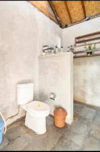 a bathroom with a white toilet in a room at Al-Shifa Healing House Lombok in Gili Air