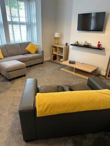 un soggiorno con divano e TV a schermo piatto di The Alvaros Apartment a Southend-on-Sea