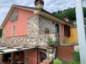 una casa con un edificio de piedra con macetas. en La casetta al lavatoio, en Borgo a Mozzano