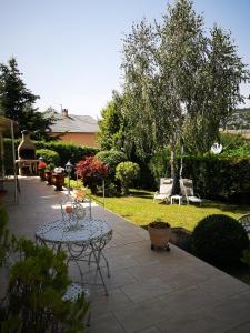 a patio with a table and chairs in a yard at Le Mimat - Jardin - Wifi - Parking in Mende