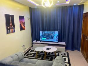 a living room with a couch and a tv at Apartment Diamant in Cotonou