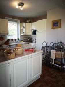 a kitchen with white cabinets and baskets on a counter at Le Mimat - Jardin - Wifi - Parking in Mende