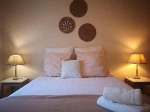- une chambre avec un lit blanc et 2 lampes dans l'établissement Le Mimat - Jardin - Wifi - Parking, à Mende