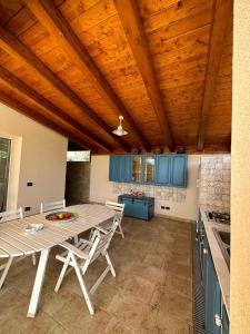 a kitchen with a table and chairs and blue cabinets at Villa Valentina in Cefalù
