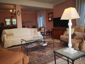 a living room with a couch and a table at Le Mimat - Jardin - Wifi - Parking in Mende