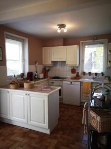 a kitchen with white cabinets and white counters at Le Mimat - Jardin - Wifi - Parking in Mende