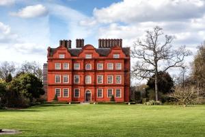 un grande edificio in mattoni rossi su un prato di Kew Bridge Apartment a Londra