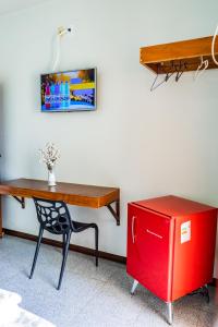 a desk with a chair and a red refrigerator at Pousada Paraiso in Guanambi