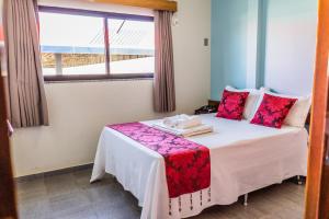 a hotel room with a bed with a window at Pousada Paraiso in Guanambi