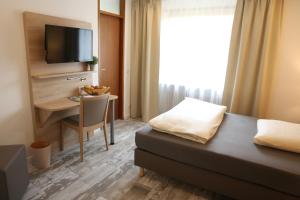 a hotel room with a bed and a table and a desk at Kemnater Hof Apartments in Ostfildern