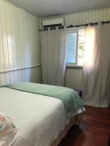 ein Schlafzimmer mit einem Bett und einem Fenster in der Unterkunft Hospedaria Rural Recanto Verde dos Canyons in Praia Grande