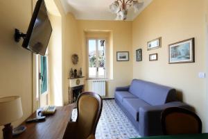 ein Wohnzimmer mit einem blauen Sofa und einem Tisch in der Unterkunft Chez Pancrazio in Taormina