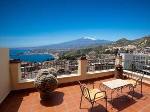 einen Balkon mit einem Tisch und Stühlen sowie Aussicht in der Unterkunft Chez Pancrazio in Taormina