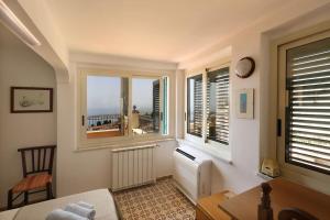a bedroom with two windows with a view of a city at Chez Pancrazio in Taormina