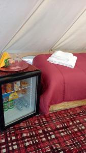 a tent with a bed and a refrigerator at Yurta con uso piscina e vista meravigliosa in Dicomano