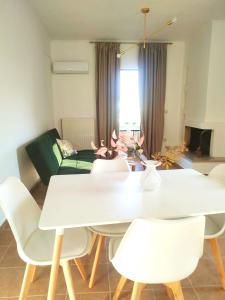 een woonkamer met een witte tafel en stoelen bij Anna's Cozy Flat in Lefkada