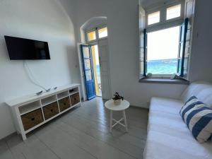 a living room with a couch and a tv and a table at Vera Mare in Agia Marina