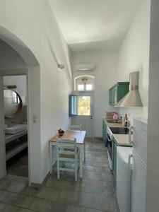 a kitchen with green cabinets and a table in it at Vera Mare in Agia Marina