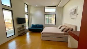 ein Schlafzimmer mit einem Bett und einem blauen Stuhl in der Unterkunft New Cozy 3 Bedroom House in Davao City