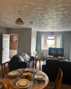 uma sala de estar com uma mesa e um sofá em Entire 2 bedroom house. em Rowley Regis