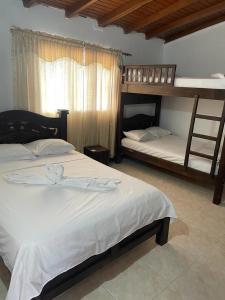 2 Betten in einem Zimmer mit 2 Etagenbetten in der Unterkunft Hotel La Casona in Chinácota