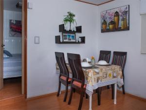 une table à manger avec quatre chaises et un tissu de table dans l'établissement Cómodo Departamento Privado Aeropuerto 7 Min caminando, à Mexico