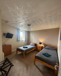 um quarto com 2 camas e tectos em caixotões em Entire 2 bedroom house. em Rowley Regis