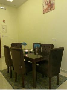 a dining room with a wooden table and chairs at القصر المطار in Abha