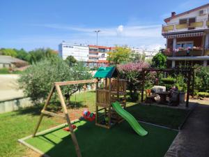 a playground with a slide in a yard at Apartmani Petra in Umag