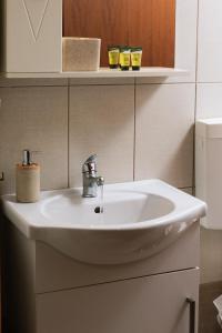 a white sink in a bathroom with two glasses on a shelf at Apironero Plouti House in Ploutí