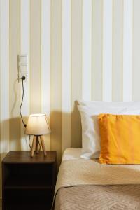 a bedroom with a bed with a lamp and a striped wall at Apironero Plouti House in Ploutí