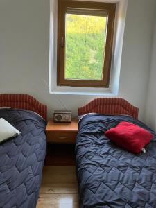 um quarto com 2 camas e uma secretária com uma janela em Stone house em Cetinje